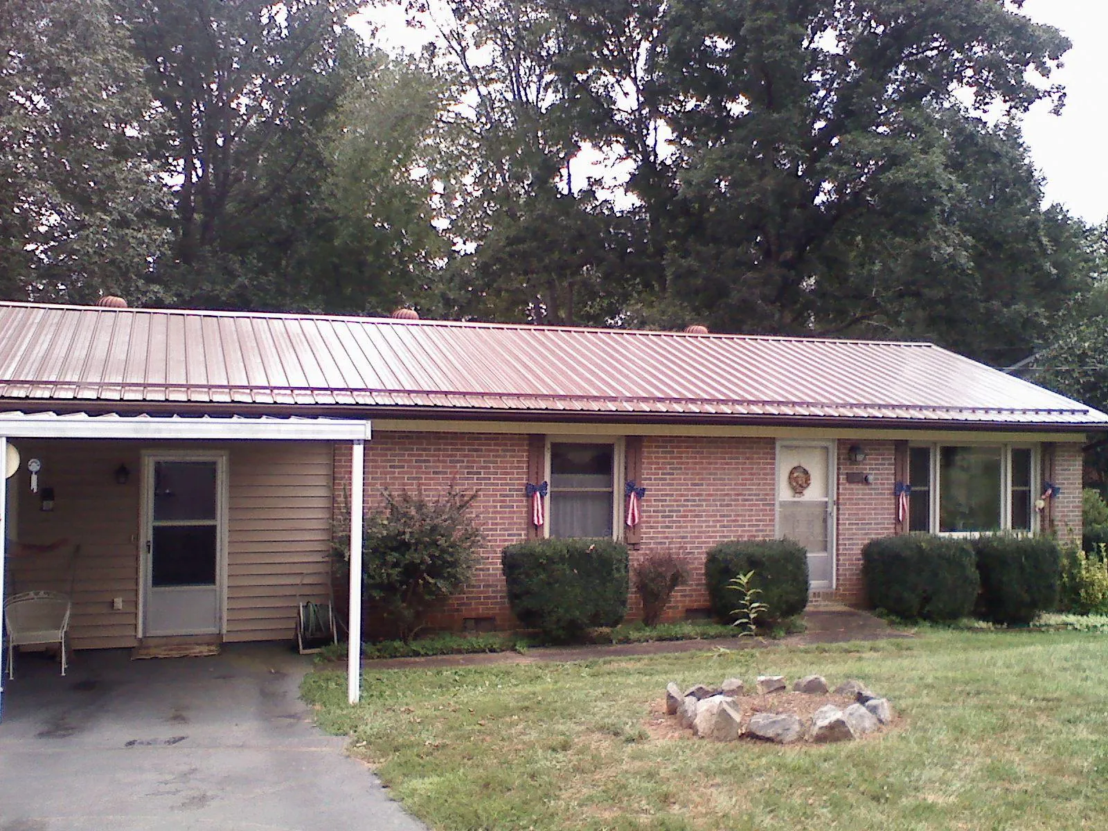 Bronze metal roof and carport on a brick ranch home — Roof Repair work by our crew in Pierce